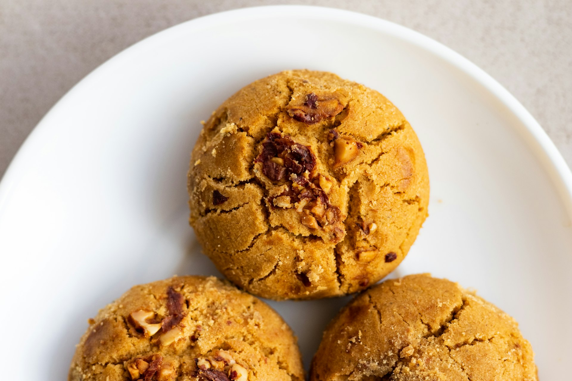 a white plate topped with three cookies on top of a table